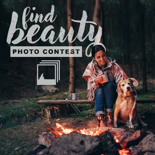 Photo contest asset showing a woman with a dog beside a campfire in a dark forest, holding an enamel mug.