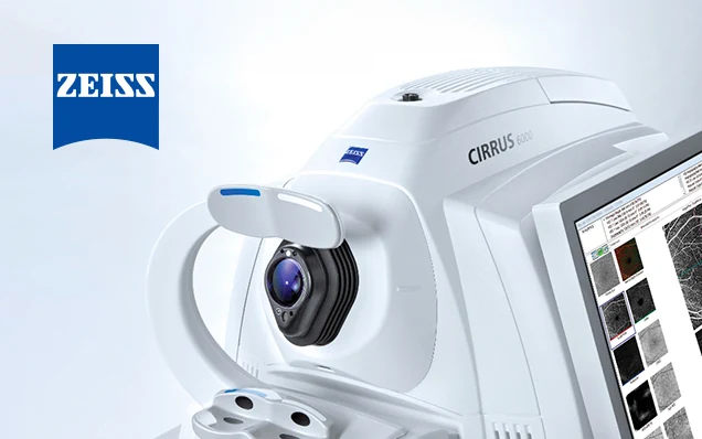 ZEISS CIRRUS 6000 imaging platform photographed against pale blue, with retinal scan data on the adjacent display and the ZEISS mark at upper left.